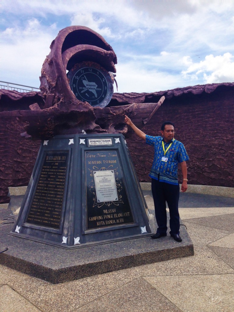 Mahlizar Zakaria points to a clock commemorating the time the tsunami hit.
